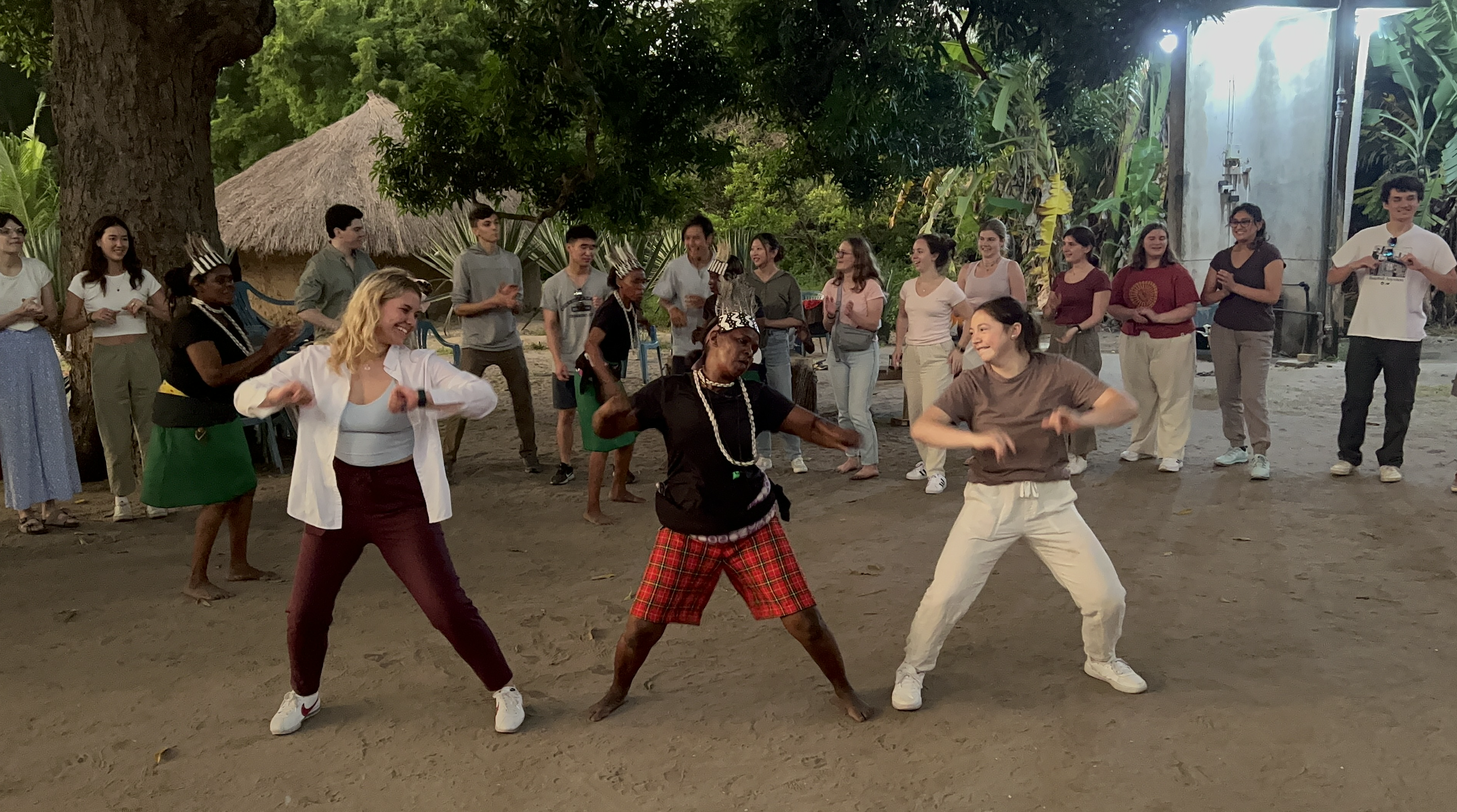 A couple students, Abby and Soria, dancing with a local in the middle of a dance circle.